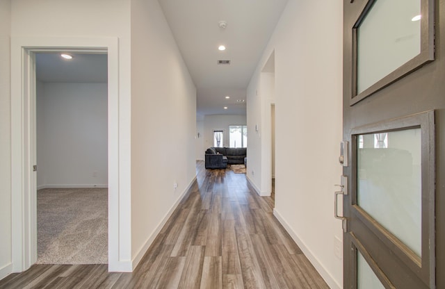 corridor with hardwood / wood-style flooring