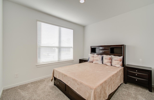 bedroom featuring light colored carpet and multiple windows