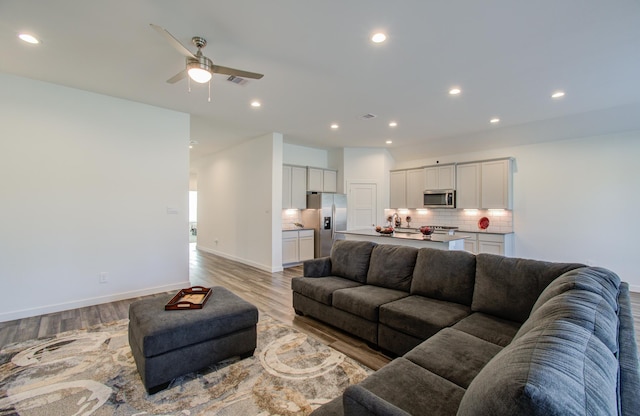 living room featuring ceiling fan and light wood-type flooring