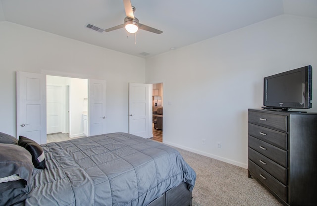 bedroom with lofted ceiling, light carpet, ceiling fan, and ensuite bath