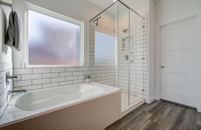 bathroom with hardwood / wood-style floors and independent shower and bath