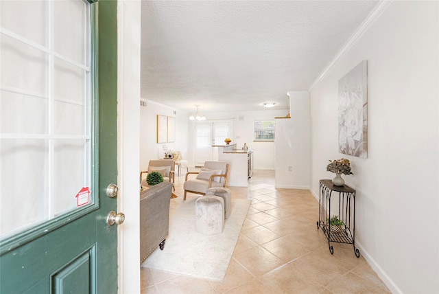 tiled entrance foyer featuring crown molding, a chandelier, and a textured ceiling