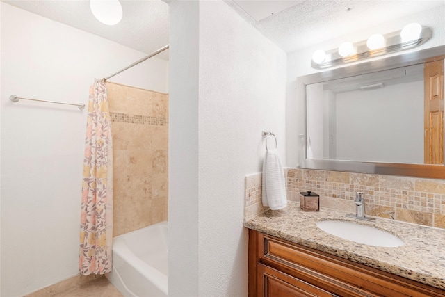 bathroom featuring tasteful backsplash, vanity, a textured ceiling, and shower / bath combo