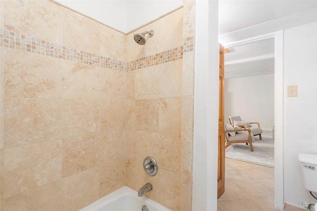 bathroom featuring toilet and tiled shower / bath combo