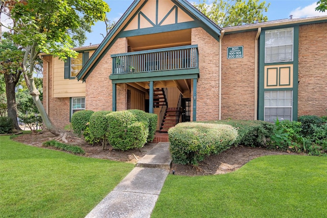 view of front of home with a front yard and a balcony