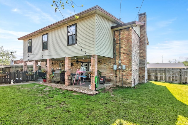 back of house with a patio and a lawn