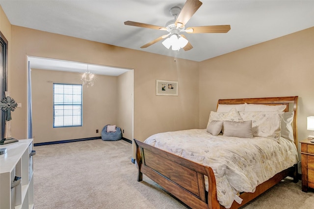 carpeted bedroom with ceiling fan with notable chandelier