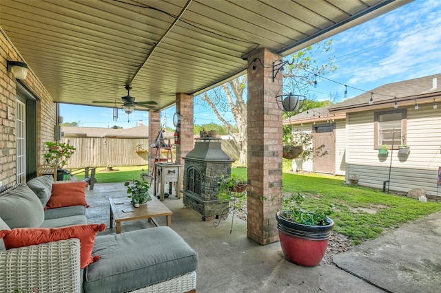 view of patio / terrace featuring ceiling fan and an outdoor living space with a fireplace