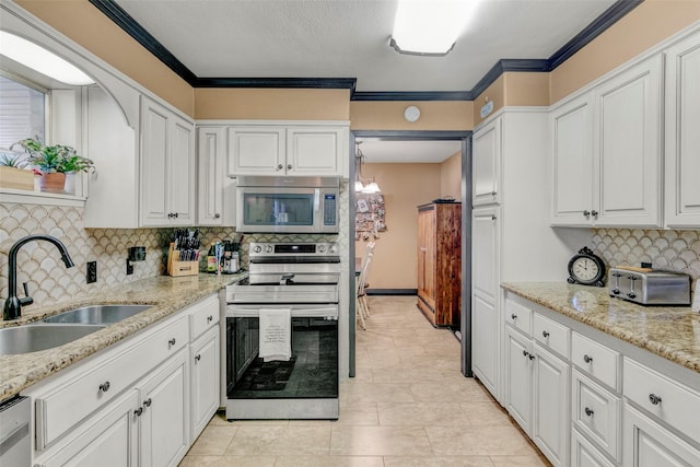 kitchen featuring stainless steel appliances, sink, white cabinets, and light stone counters