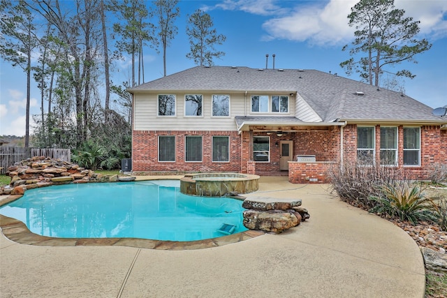 back of house with a swimming pool with hot tub and a patio