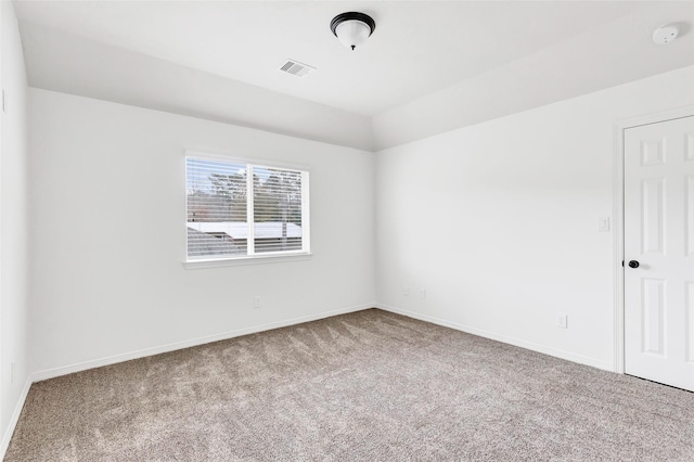 empty room featuring carpet flooring and vaulted ceiling