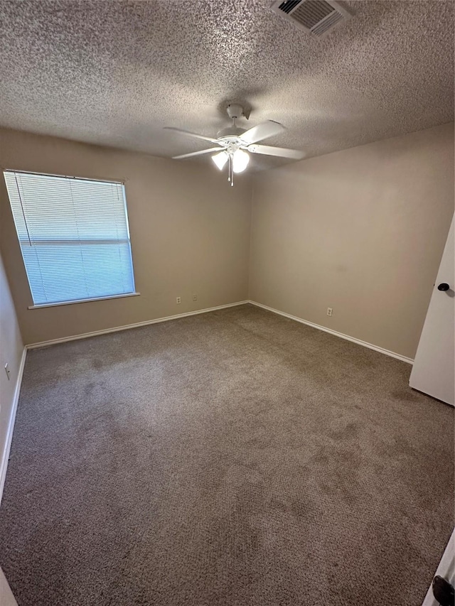 empty room featuring a textured ceiling, carpet floors, and ceiling fan