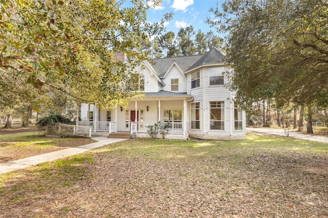 victorian-style house with a porch and a front lawn