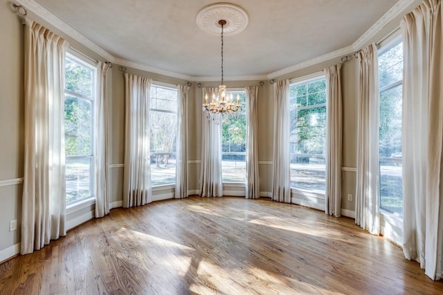 unfurnished dining area featuring a healthy amount of sunlight, a chandelier, and light wood-type flooring