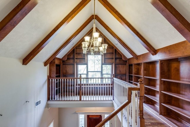 interior space featuring vaulted ceiling with beams and a chandelier