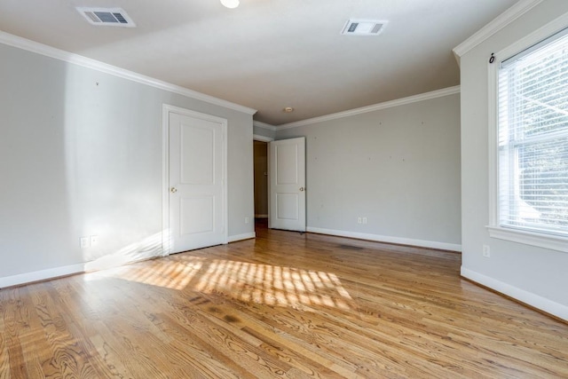 spare room featuring crown molding and light wood-type flooring