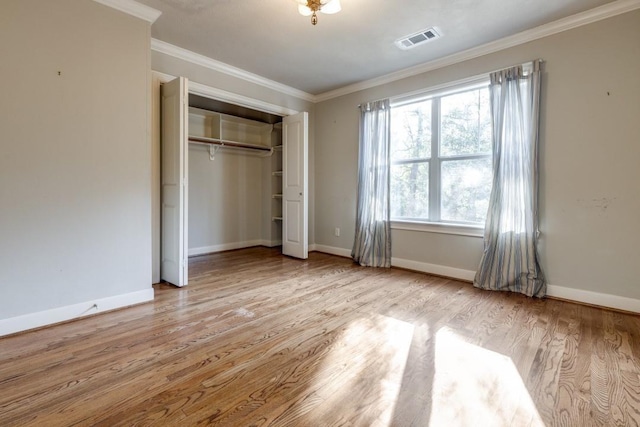 unfurnished bedroom featuring ornamental molding, light hardwood / wood-style floors, and a closet