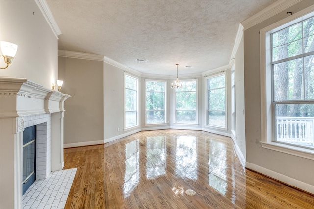 36111 Post Oak Cir, Magnolia, TX 77355 - unfurnished dining area featuring a chandelier, wood finished floors, a fireplace, crown molding, and a textured ceiling