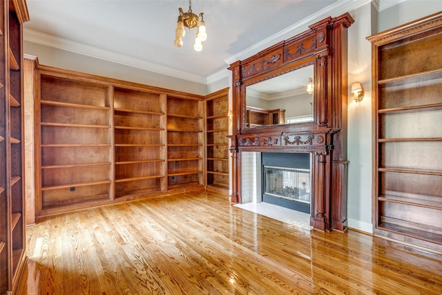 36111 Post Oak Cir, Magnolia, TX 77355 - unfurnished living room featuring a fireplace with flush hearth, ornamental molding, wood finished floors, and a chandelier