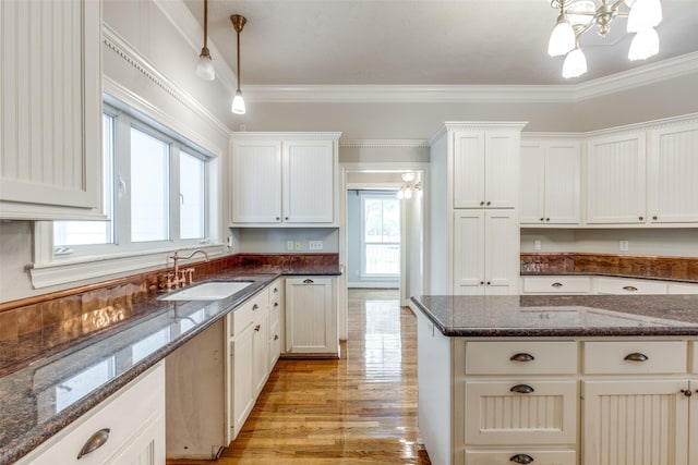 36111 Post Oak Cir, Magnolia, TX 77355 - kitchen with plenty of natural light, pendant lighting, ornamental molding, light wood-style flooring, and dark stone countertops