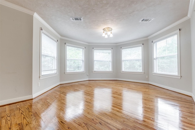 36111 Post Oak Cir, Magnolia, TX 77355 - unfurnished room with plenty of natural light, wood finished floors, a chandelier, crown molding, and a textured ceiling
