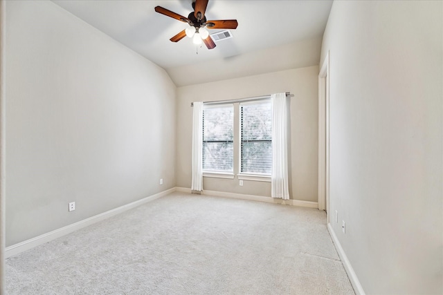 carpeted spare room with ceiling fan and vaulted ceiling