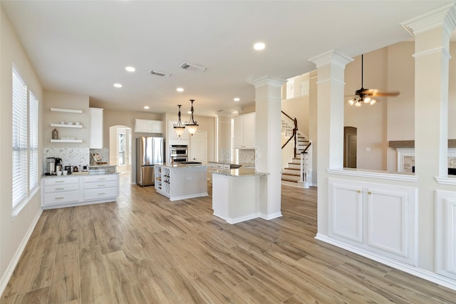 kitchen with tasteful backsplash, white cabinetry, appliances with stainless steel finishes, and a center island