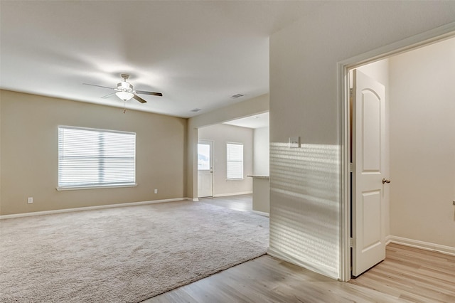 empty room with light hardwood / wood-style floors and ceiling fan