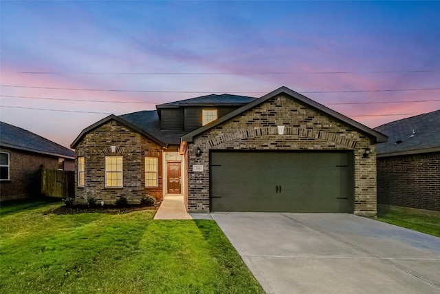 view of front of property featuring a garage and a lawn