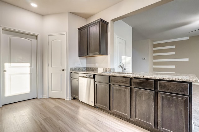 kitchen with sink, light stone counters, dark brown cabinets, stainless steel dishwasher, and light hardwood / wood-style floors