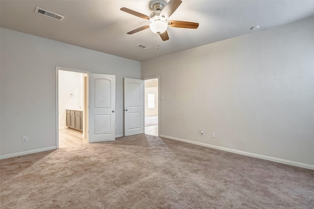 unfurnished bedroom with ceiling fan, light colored carpet, and ensuite bath