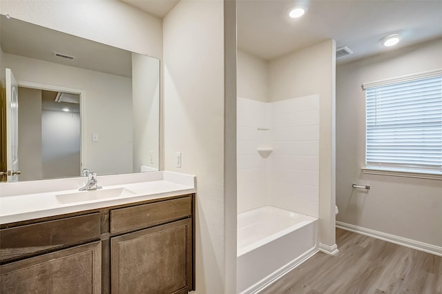 bathroom featuring vanity, wood-type flooring, and tub / shower combination