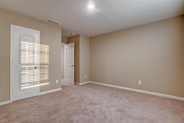 unfurnished room featuring light colored carpet