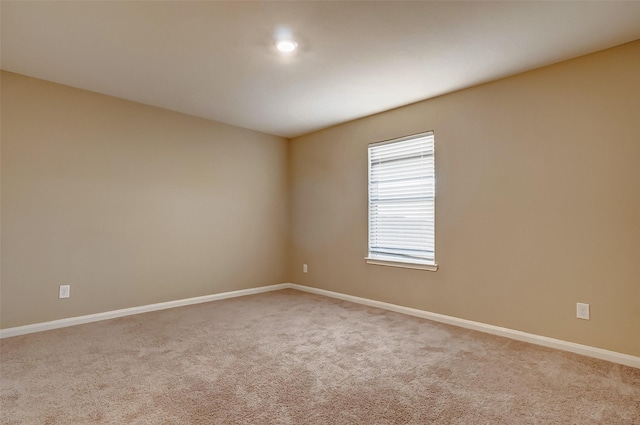 spare room featuring light carpet