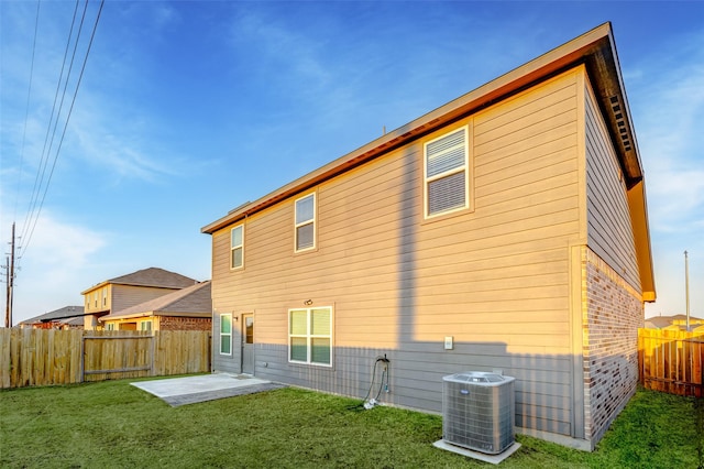 back of house with central AC, a yard, and a patio