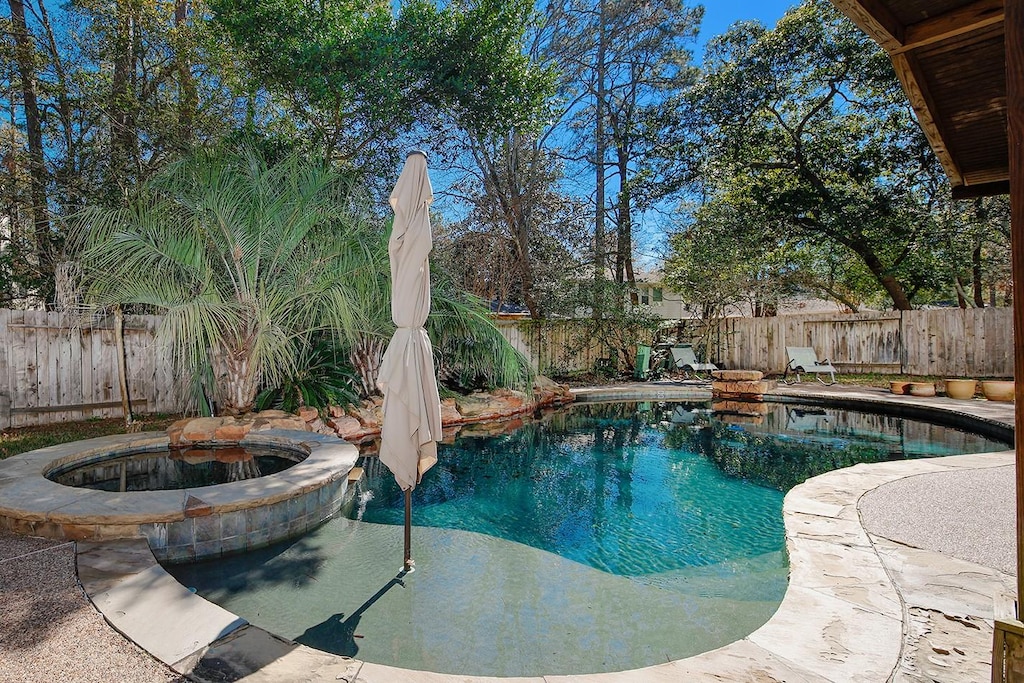 view of swimming pool featuring an in ground hot tub