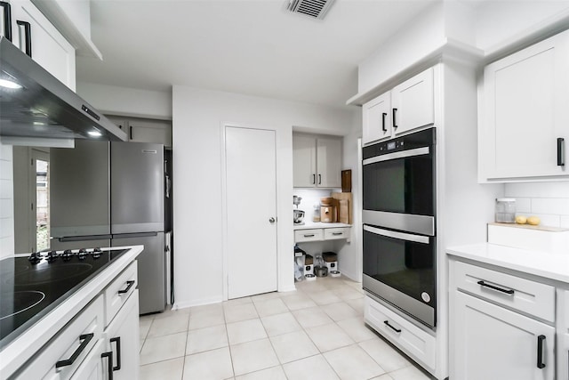 kitchen with visible vents, light countertops, wall chimney exhaust hood, decorative backsplash, and black appliances