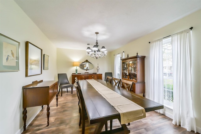 dining area featuring wood finished floors and an inviting chandelier