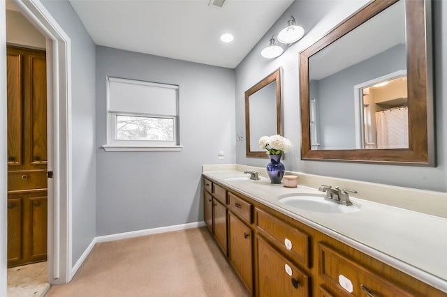 bathroom with double vanity, baseboards, and a sink