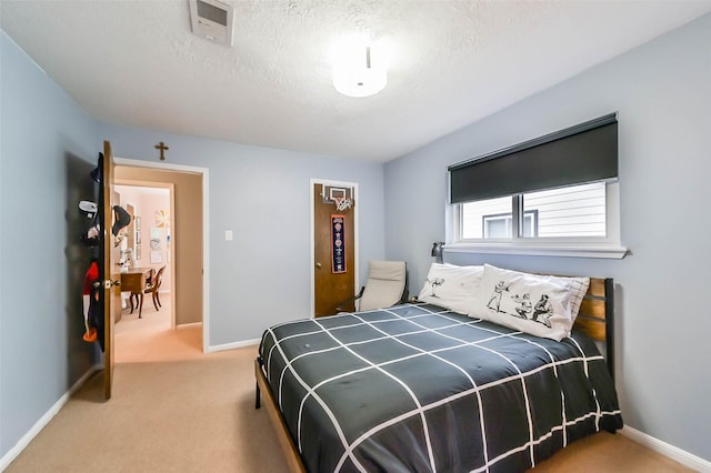 carpeted bedroom with a textured ceiling, visible vents, and baseboards