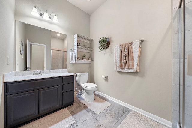 bathroom featuring vanity, a shower with door, and toilet