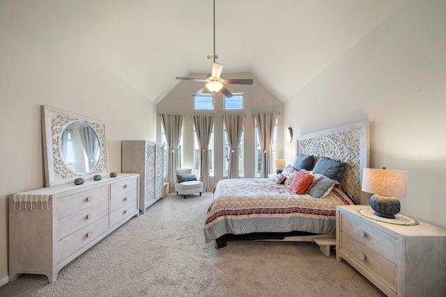 carpeted bedroom with ceiling fan and high vaulted ceiling