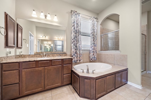 bathroom with tile patterned flooring, vanity, and separate shower and tub