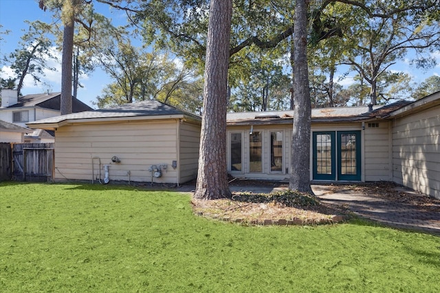 back of property with a lawn and french doors