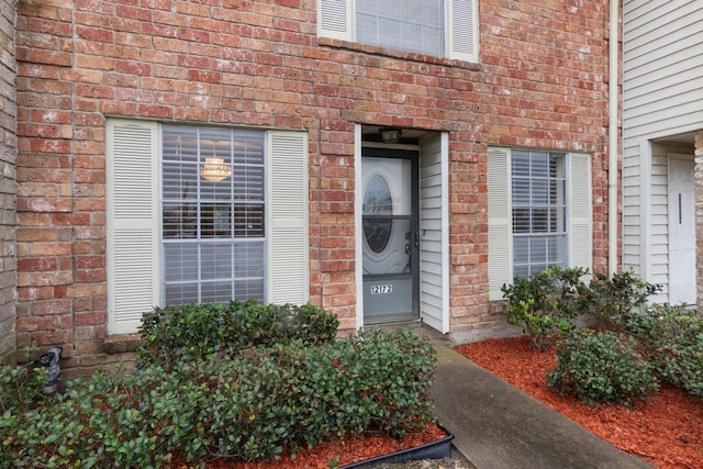 entrance to property featuring brick siding