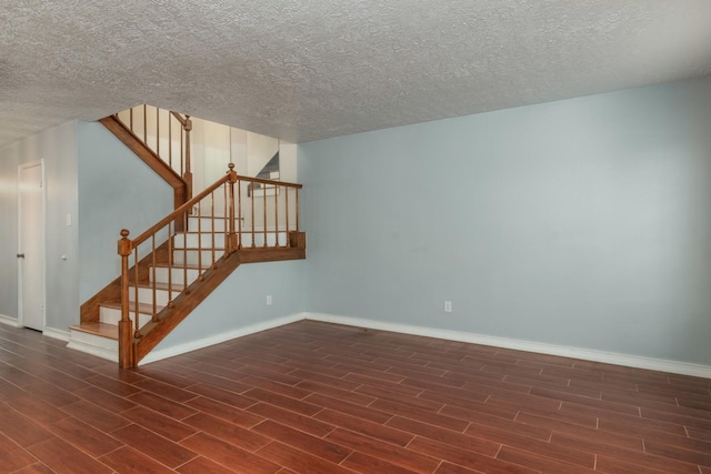 unfurnished room featuring stairway, wood finished floors, and baseboards