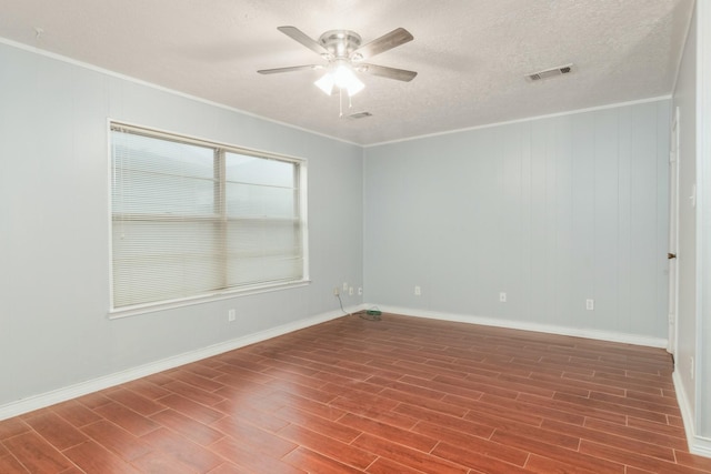 spare room with ornamental molding, visible vents, and wood finished floors