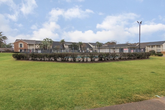 view of front facade with a front lawn, fence, and a residential view