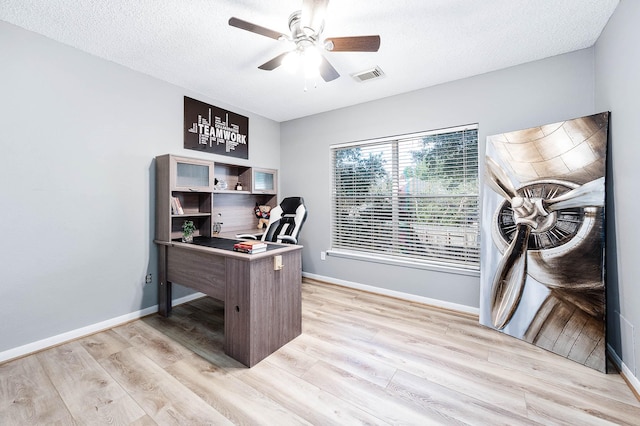 office area with a textured ceiling, light hardwood / wood-style floors, and ceiling fan