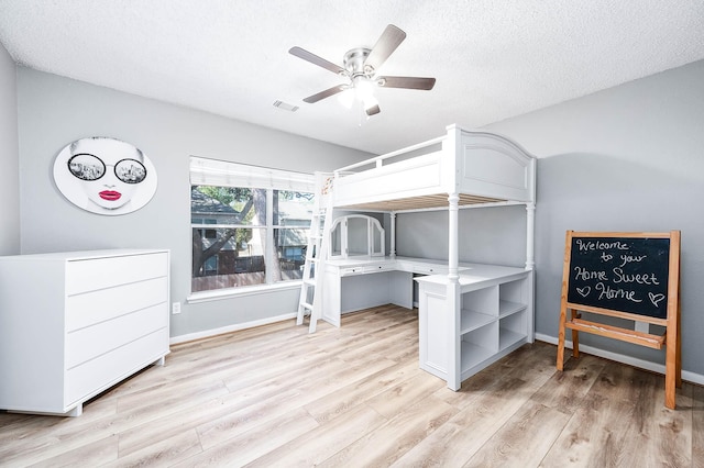 bedroom featuring a textured ceiling, ceiling fan, and light hardwood / wood-style floors